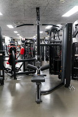 sstkWellness captures the essence of modern fitness with this striking image of a mechanical strength training machine loaded with weight plates, highlighting the synergy between structured physical