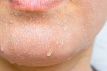 Close-up of a woman's face sweating in the hot summer