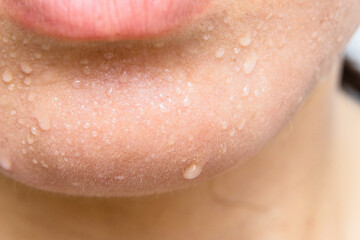 Close-up of a woman's face sweating in the hot summer