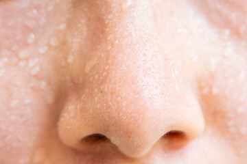 Close-up of a woman's face sweating in the hot summer