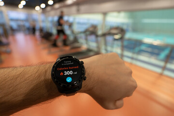 man at the stadium checks the number of calories burned in his smartwatch. Daily exercise in the fresh air for weight loss. all the graphics on the screen are made up. sporty lifestyle.
