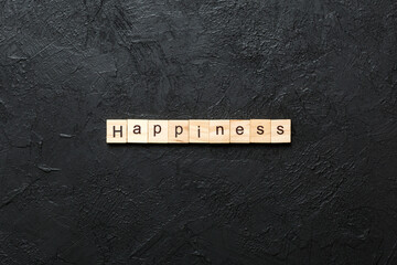 Happiness word written on wood block. Happiness text on table, concept