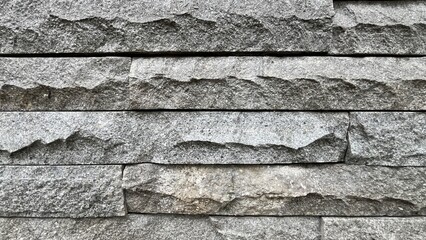 Textured gray stone wall background. Natural building material with rough surface pattern, suitable for architecture, construction, and design. 