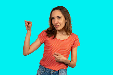 Fototapeta premium Young woman snapping fingers on turquoise background