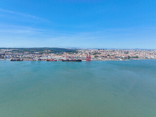 Fototapeta premium Aerial view of the Ports of Lisbon with large cargo ships and red cranes along the waterfront