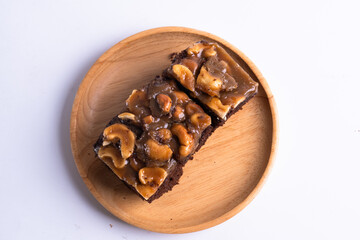 Cashew toffee cake in wood plate on white background