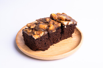 Cashew toffee cake in wood plate on white background
