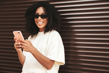 Beautiful woman with afro curls hairstyle.Smiling hipster model in white t-shirt. Sexy carefree...