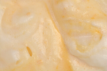 A close-up captures the light yellow, airy texture of a biscuit batter being prepared