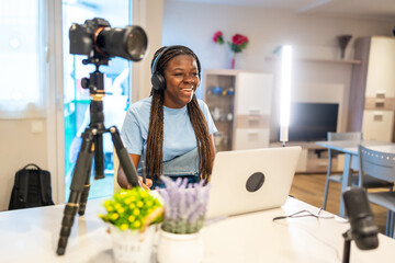 Teenage girl recording video content at home using laptop and camera