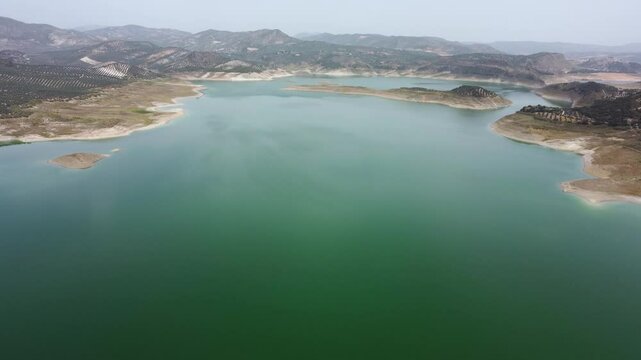 Aerial drone view of Iznajar Reservoir. Also known as the Lake of Andalusia, is located in the middle course of the Genil River, being the largest reservoir in Andalusia. Drone going forward.