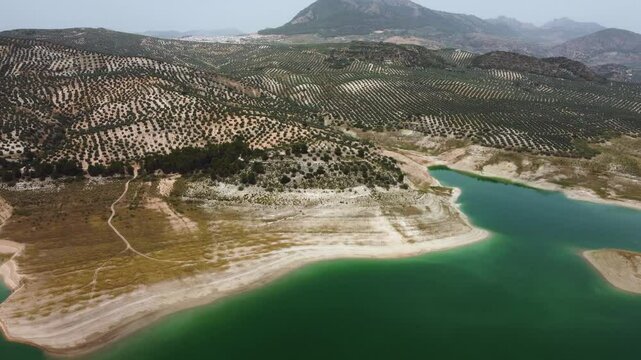 Aerial drone view of Iznajar Reservoir. Also known as the Lake of Andalusia, is located in the middle course of the Genil River, being the largest reservoir in Andalusia. Drone going forward.
