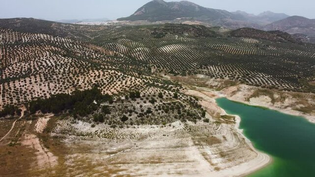 Aerial drone view of Iznajar Reservoir. Also known as the Lake of Andalusia, is located in the middle course of the Genil River, being the largest reservoir in Andalusia. Drone going backwards.
