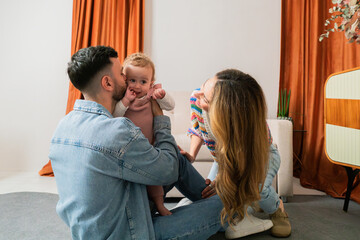 Joyful family moment as parents playfully interact with their adorable baby, capturing the essence of love and happiness in a delightful and heartwarming scene filled with laughter