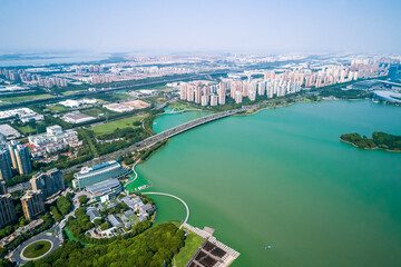 Obraz premium Skyline view of a vibrant urban landscape near a green lake showcasing modern architecture and extensive greenery