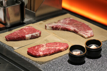 
Three expertly grilled steaks, sliced and fanned out to show their juicy, medium-rare interiors, are presented on rustic wooden cutting boards