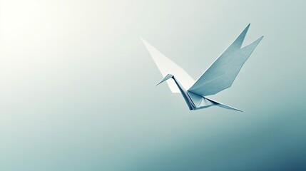 Graceful origami crane taking flight against a soft background.