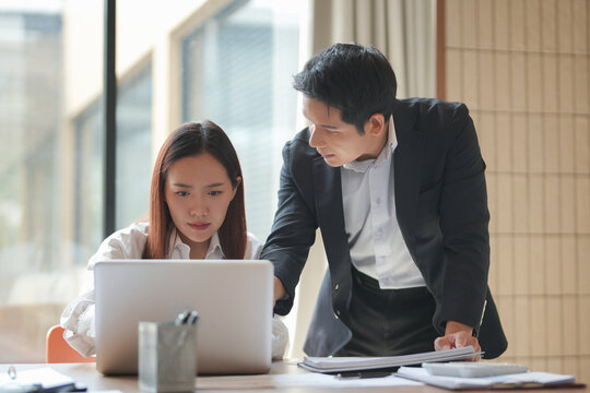 Asian office employee supervising Mentor training trainee at office