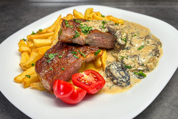 Juicy grilled pork neck, baked potatoes and creamy morel sauce