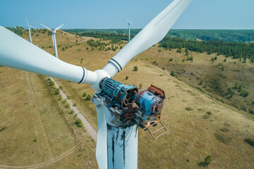 Aerial shot of wind turbine with fire damage in a rural landscape during the daytime