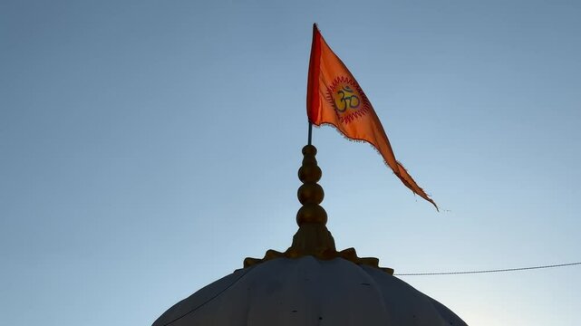 Orange Flag wavering with the logo of Om waving on top of the temple,