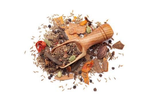 A wooden scoop filled with organic warming spices or whole Garam Masala, placed on a heap of whole spices, isolated on a white background.