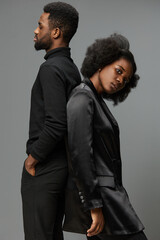 Elegant couple in stylish black outfits, showcasing confidence and emotion against a neutral background, perfect for themes of modern romance and fashion