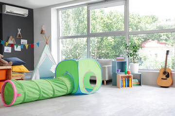 Interior of kindergarten with play tunnel and tent
