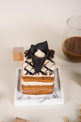A Slice Of Cake Topped With Chocolate On Top With An Elegant Background Looks Aesthetic And Very Appetizing.