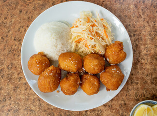 Fried chicken balls with rice and fresh cabbage salad closeup. Deep fried dough balls