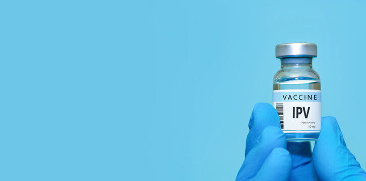 Doctor wearing protective medical gloves holding an IPV (inactivated poliovirus) vaccine bottle on a blue background, symbolizing healthcare,modern medicine,disease prevention,vaccination awareness