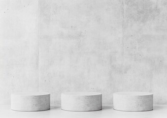 Three round concrete podiums against a textured wall
