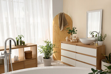 Interior of bathroom with shelf unit, commode and plants