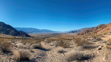 A vast desert landscape with mountains under a clear blue sky.