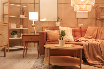 Interior of stylish living room with brown sofa, coffee table and glowing lamps at evening