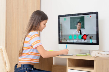 Teenage girl studying Math with tutor online at table in room