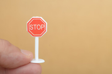 Small STOP Sign Held by Hand – Minimalist Concept of Halt and Safety