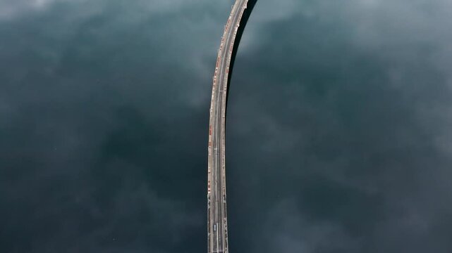 wide aerial View of High Bridge of Servia at Kozani GREECE its is a top down view of the bridge while tracking following cars reflection of the clouds at the lake and the bridge middle of the frame