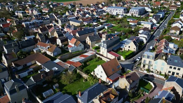 Top-down drone view of the suburban neighborhood with rows of houses and winding streets, Saint-Aubin-sur-Mer, Normandy, France.
