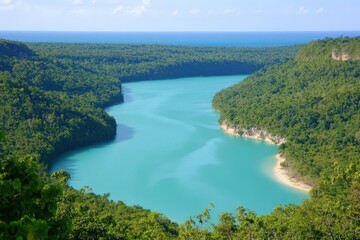 Obraz premium Serene lake reflecting the vibrant sky, surrounded by dense tropical foliage.