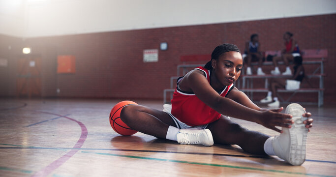 Basketball player, woman and stretching with exercise at gym, ready and fitness for league playoffs. Person, workout and start warm up with gear for contest, competition and legs on court with sports