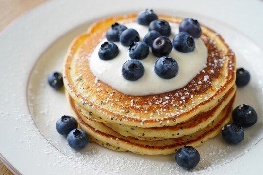Stack of lemon poppy seed pancakes topped with yogurt and blueberries - Powered by Adobe