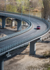 Red car driving on overpass, aerial view