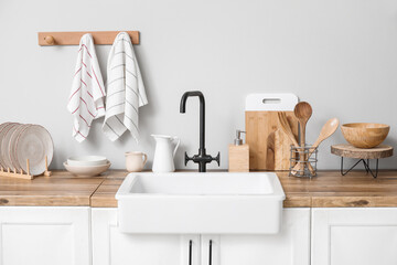 Counter with sink, utensils and clean towels in kitchen