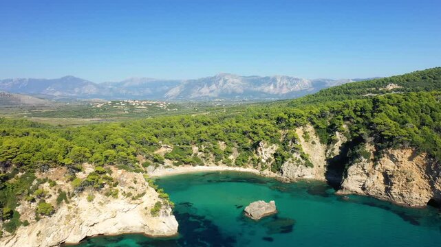 The fine sandy beach of Alonaki Fanariou bordered by its green cliffs, in Europe, in Greece, in Epirus, towards Igoumenitsa, on the edge of the Ionian Sea, in summer, on a sunny day.&nbsp;