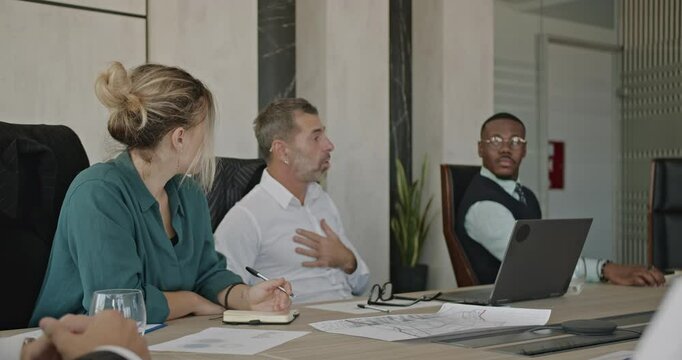 Multiracial and inter generational business team in a meeting, brainstorming, discussing ideas, and strategizing for growth.