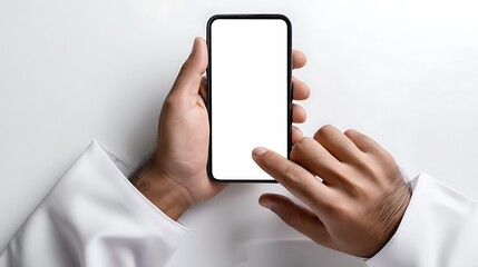Hands of Arabian Man with White Saudi Dress is Using and Touching Smartphone with White Blank Screen Mockup : Suitable for Be Used in Content Related to Technology Theme.