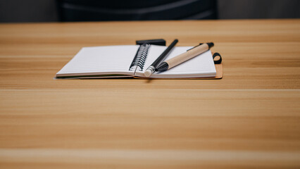Top view of minimal workspace with notebook, pencil, pen, eraser on wooden desk. Perfect setup for writing, studying, planning, or remote work. Flat design