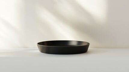 Empty black bowl on a white surface