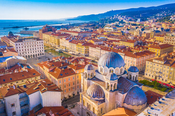 A unique aerial view of city center landmarks in Trieste, Italy, capturing the church’s striking domes, elegant architecture, and the surrounding urban landscape of this Adriatic city
